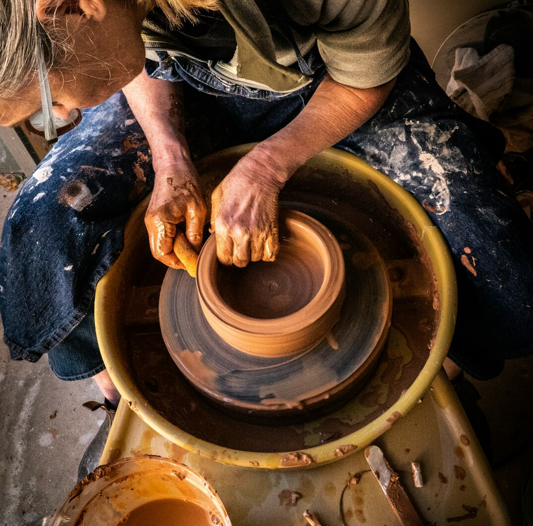 potter shaping clay on wheel