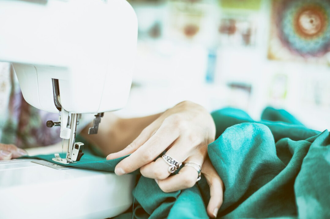person sewing fabric by hand
